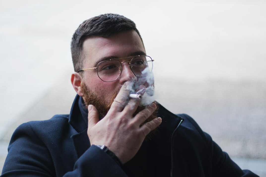 Portrait of a man with short beard and glasses in an archive